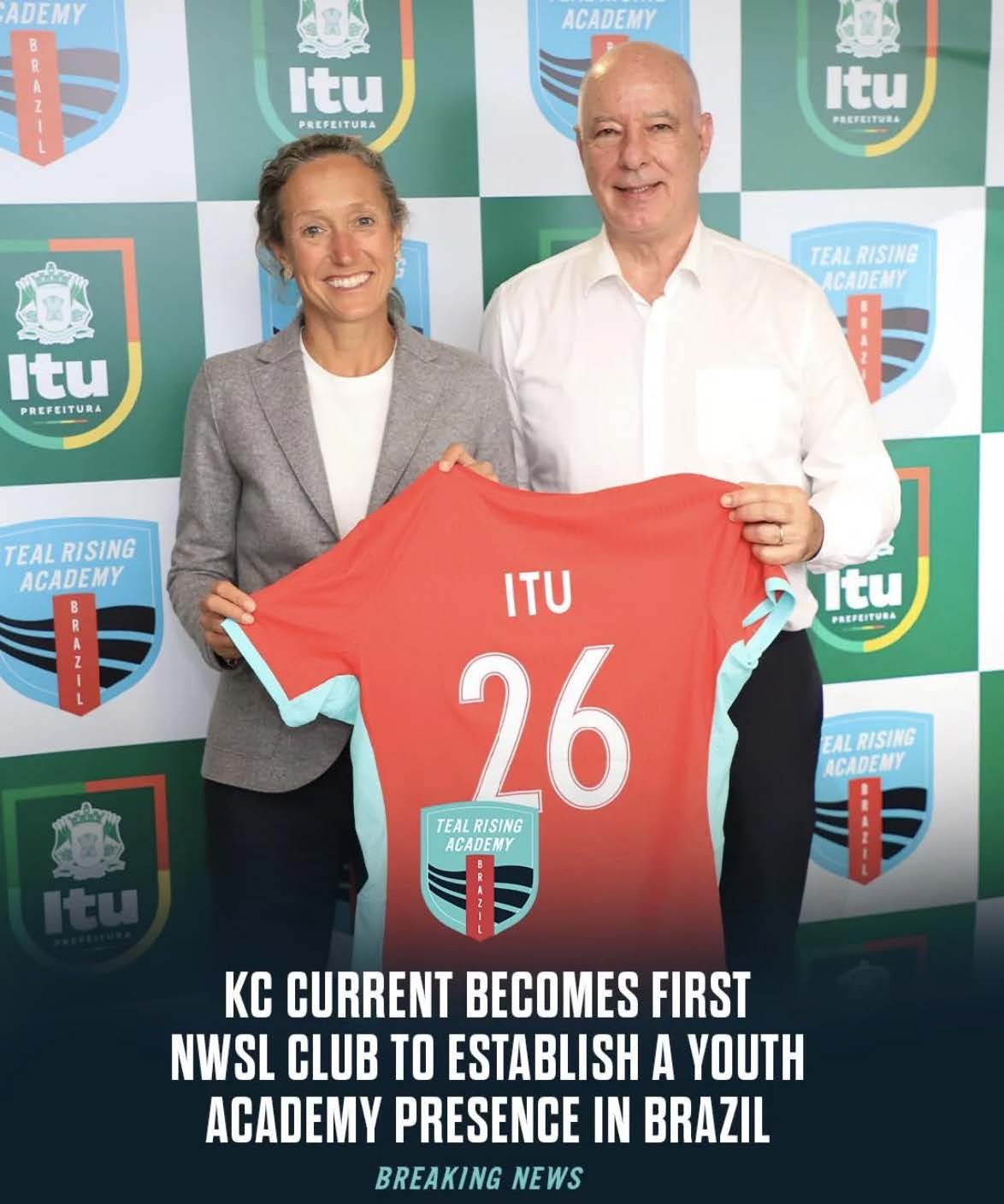 Mulher de blazer cinza e homem de camisa branca seguram uma camisa coral diante de painel do Teal Rising Academy Brazil, com a marca da Prefeitura de Itu.